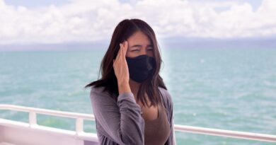 Woman suffering from sea sickness and feeling headache while on boat