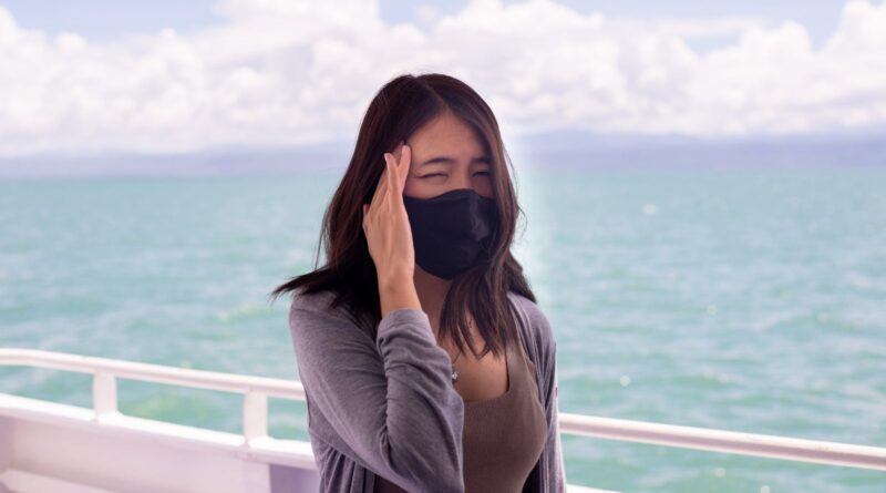 Woman suffering from sea sickness and feeling headache while on boat