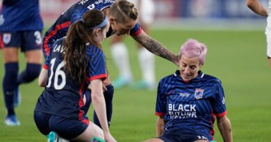 OL Reign forward Megan Rapinoe, right, stays down after sustaining a non-contact injury