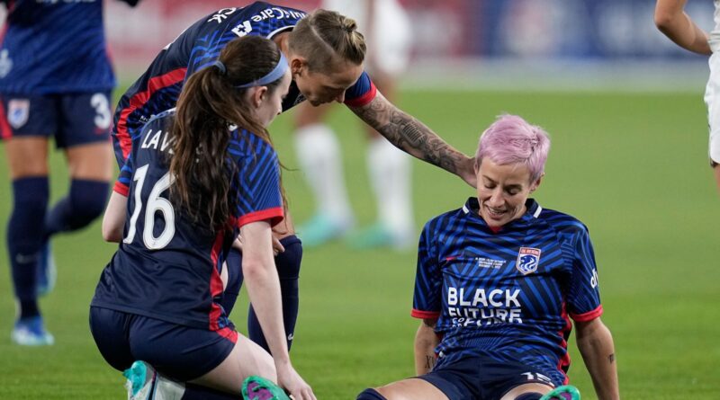 OL Reign forward Megan Rapinoe, right, stays down after sustaining a non-contact injury