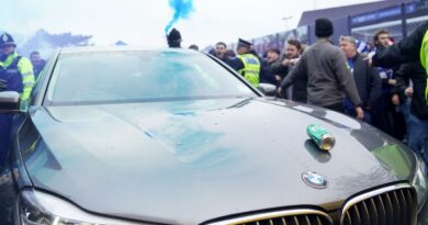 A beer can lands on the bonnet of the car taking Delia Smith to the East Anglian derby