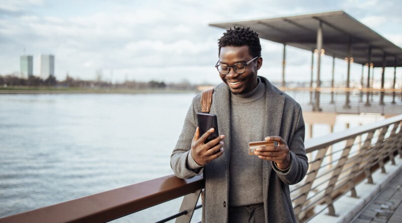 Afro american businessman using smart phone on city street