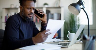 Worried man talking on the phone while working from home