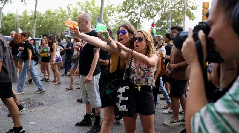 Fed up with tourists, Barcelona protesters blast them with water guns